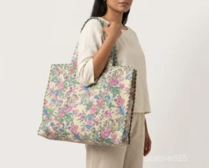 Close-up of the beige cotton print detailing, dense parallel line quilted stitching rows, integrated interior pocket, and comfortable 13-inch shoulder handles on an Indian cotton tote bag.