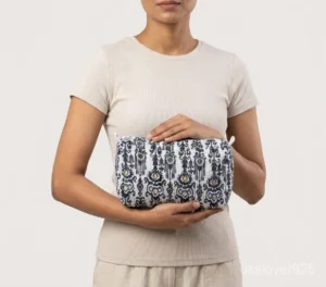 Close-up of the handcrafted black floral print detailing, dense vertical quilted stitching rows, waterproof internal plastic lining, and built-in inside slots on an Indian cotton cosmetic caddy pouch.