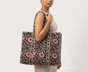 Close-up of the black block print detailing, dense parallel line quilted stitching rows, recycled cotton lining, and comfortable shoulder handles on an Indian cotton tote bag.