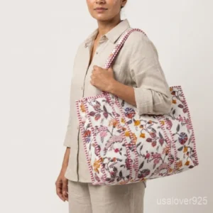 Close-up of the black and white botanical print detailing, dense parallel line quilted stitching rows, wide profile layout, and comfortable handles on an Indian cotton tote bag.