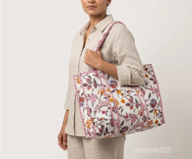 Close-up of the black and white botanical print detailing, dense parallel line quilted stitching rows, wide profile layout, and comfortable handles on an Indian cotton tote bag.