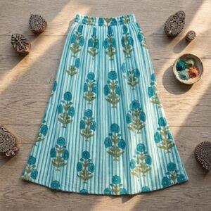 Close-up of the handcrafted blue botanical blossom print detailing, striped pattern accents, soft cotton fabric texture, and gathered waist layers on an Indian cotton midi skirt.