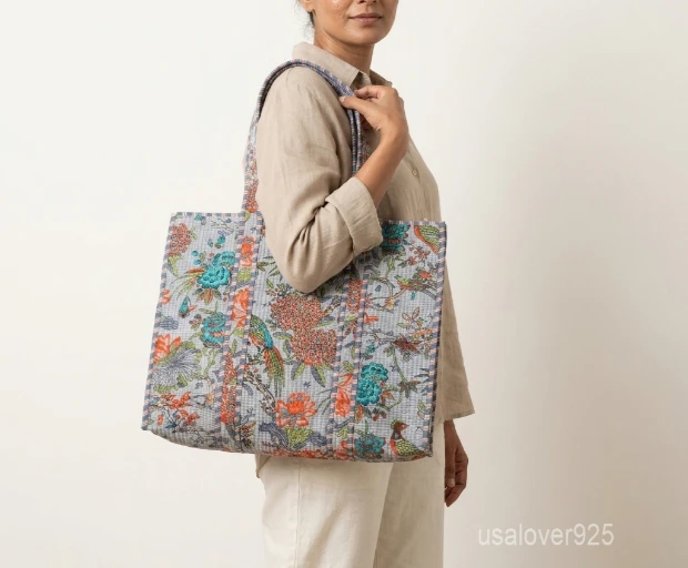 Close-up of the hand block floral prints, dense parallel line quilted stitching, and roomy side gusset on an Indian cotton shopper bag.