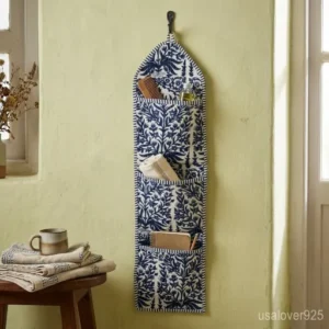 Blue Floral Hanging Wall Organizer with 3 deep pockets hanging in a bedroom entryway.