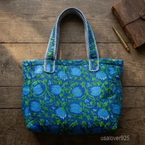 A person walking down a city market path carrying a large Blue Floral Kantha Quilted Cotton Tote Bag comfortably over their shoulder.
