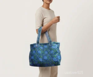 Close-up of the dense Kantha running stitches, reversible inner pattern, and reinforced double shoulder strap details on a blue cotton tote bag.