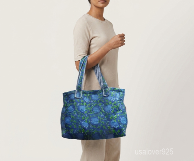 Close-up of the dense Kantha running stitches, reversible inner pattern, and reinforced double shoulder strap details on a blue cotton tote bag.