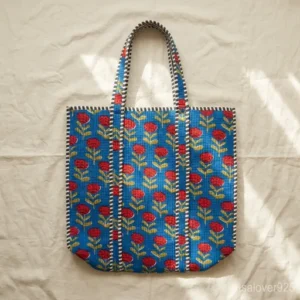 Woman walking through an outdoor market carrying an over-sized Blue Floral Quilted Cotton Tote Bag packed with books and beach essentials.