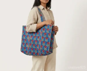 Blue Floral Quilted Cotton Tote Bag with comfortable over-the-shoulder handles held against a natural background.