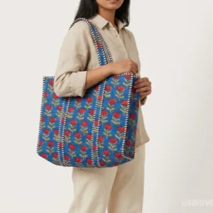 Blue Floral Quilted Cotton Tote Bag with comfortable over-the-shoulder handles held against a natural background.
