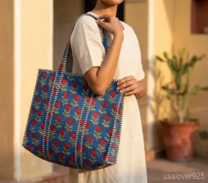 Blue Floral Quilted Cotton Tote Bag with comfortable over-the-shoulder handles held against a natural background.