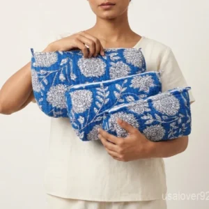 Close-up of the handcrafted blue floral block print detailing, dense vertical quilted stitching rows, waterproof internal plastic inner lining, and built-in inside storage slots on an Indian cotton cosmetic pouch caddy.