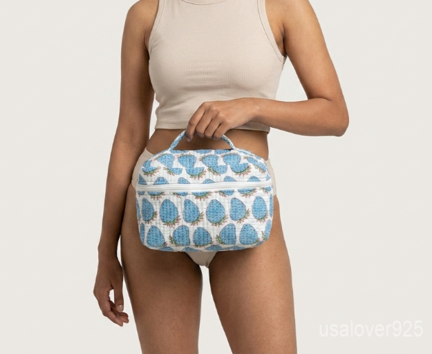 A traveler retrieving the Blue Strawberry Makeup Case from an overnight duffle bag, displaying its soft structure and vibrant cottagecore aesthetic style.