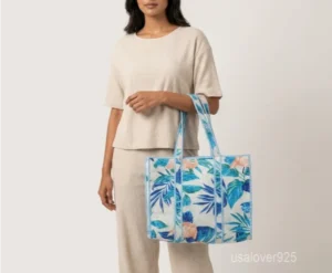 Close-up of the multicolor block print detailing, dense parallel line quilted stitching rows, supportive 6-inch bottom gusset base, and comfortable handles on an Indian cotton tote bag.