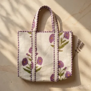 Woman walking through an outdoor market carrying an Extra Large Floral Quilted Tote packed with books and travel gear.