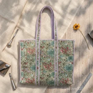 A person carrying a large Floral Block Print Quilted Cotton Tote Bag comfortably over their shoulder during a casual weekend market stroll.