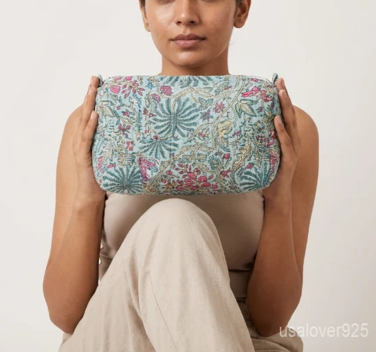 Close-up of the handcrafted floral block print detailing, dense vertical quilted stitching rows, waterproof internal lining, and built-in inside storage slots on an Indian cotton cosmetic pouch caddy.