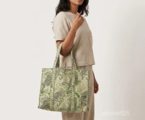 Close-up of the botanical floral print detailing, dense parallel line quilted stitching rows, and comfortable 13-inch shoulder handles on an Indian cotton tote bag.