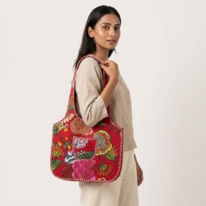 A shopper carrying the Floral Quilted Shoulder Bag Cotton Tote by the wide straps, showcasing its spacious packing capacity and elegant bohemian accessory style at an outdoor market event.