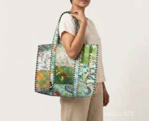 Close-up of the green botanical prints, intricate patchwork lines, dense parallel line quilted stitching, and comfortable 12-inch handles on an Indian cotton tote bag.