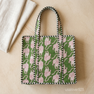 A shopper carrying the Green Tiger Quilted Tote Bag by the wide straps, showcasing its generous packing capacity and vibrant bohemian accessory style at a farmers market.