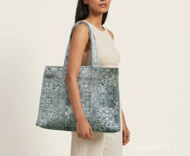 Close-up of the intricate patchwork detailing, dense parallel line quilted stitching rows, and comfortable padded shoulder handles on an Indian cotton shopper bag.