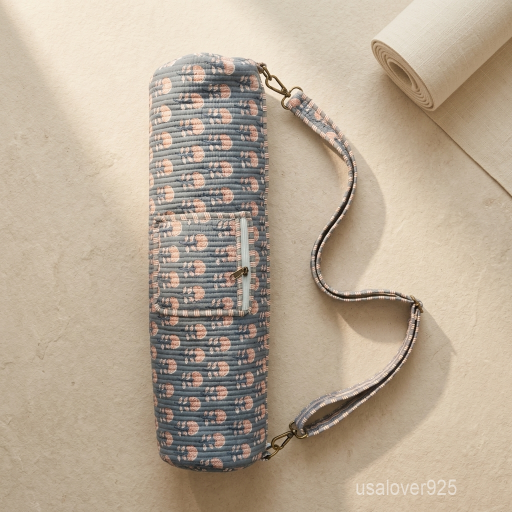 Close-up of the handcrafted grey block print detailing, dense quilted stitching tracks, heavy-duty metal clasps, and adjustable crossbody strap on an Indian cotton fitness mat bag.
