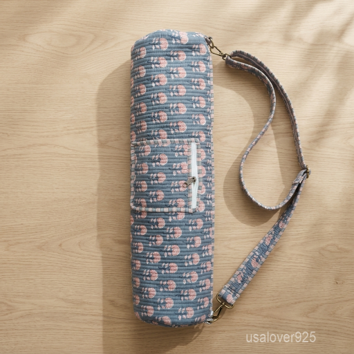 An active practitioner carrying the Grey Floral Quilted Cotton Yoga Mat Bag over the shoulder while commuting, displaying its comfortable fit and vibrant studio-ready look.