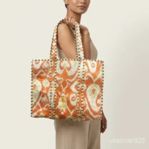 Close-up of the regional hand block print detailing, dense parallel line quilted stitching rows, deep 6-inch bottom gusset base, and comfortable handles on an Indian cotton tote bag.