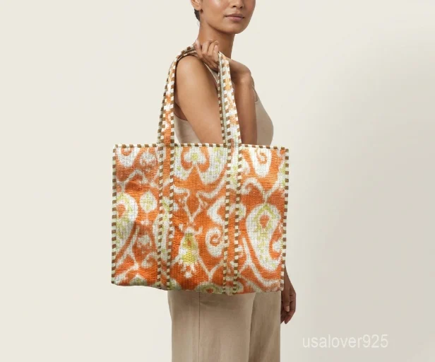 Close-up of the regional hand block print detailing, dense parallel line quilted stitching rows, deep 6-inch bottom gusset base, and comfortable handles on an Indian cotton tote bag.
