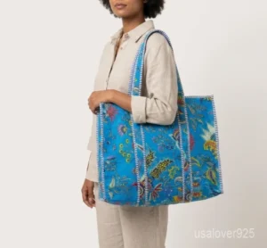 Close-up of the hand block floral prints, dense parallel line quilted stitching, and roomy side gusset on an Indian cotton shopper bag.