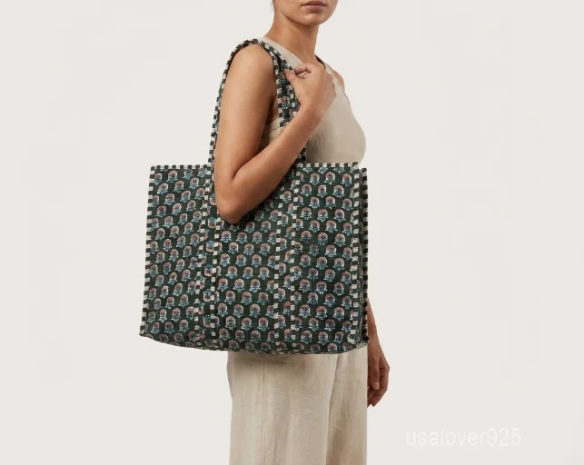 A person carrying a large Floral Indian Cotton Quilted Tote Bag comfortably over their shoulder during a casual weekend travel trip.