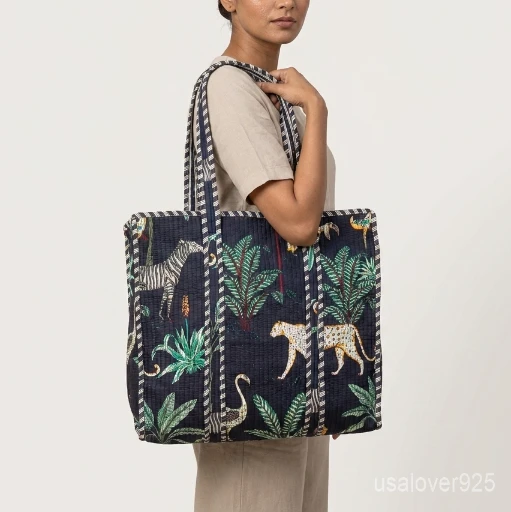 A shopper carrying the Jungle Print Quilted Cotton Tote Bag by the wide straps, showcasing its generous packing capacity and vibrant bohemian accessory style at a beach resort.