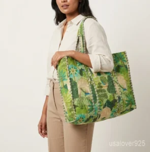 Close-up of the handcrafted royal bird block print detailing, dense quilted stitching texture lines, robust handle attachments, inner pocket slot, and solid reversible backing on an Indian cotton carryall tote.