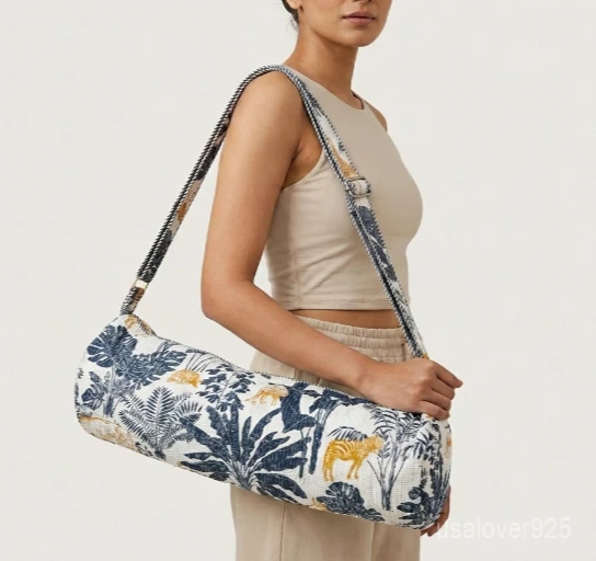 A fitness enthusiast carrying the Indigo Gold Tiger Quilted Yoga Mat Bag over the shoulder by the wide strap, showcasing its slim profile and vibrant bohemian accessory style while heading to a studio class.