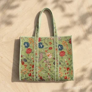 A person carrying a large Multicolor Floral Block Print Quilted Cotton Tote Bag comfortably over their shoulder during an outdoor weekend getaway travel trip.