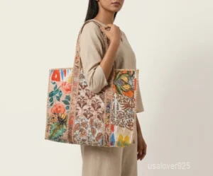 Close-up of the hand-block floral prints, dense parallel line quilted stitching, and roomy side gusset on an Indian cotton carryall bag.