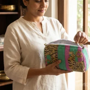 Close-up of the handcrafted traditional multicolor print detailing, dense vertical quilted stitching rows, waterproof internal plastic inner lining, and built-in inside storage slots on an Indian cotton cosmetic pouch caddy.