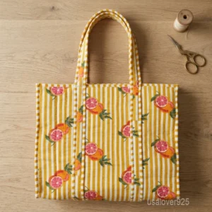 A person carrying a large Orange Floral Block Print Quilted Cotton Tote Bag comfortably over their shoulder during a casual weekend trip.