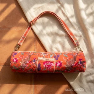 Close-up of the convenient integrated front pocket, secure enclosure system, and detailed botanical pattern details on an orange cotton yoga bag.