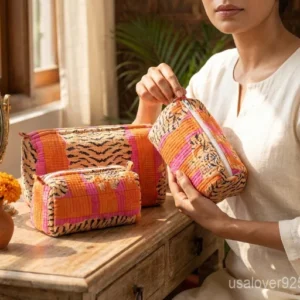 Close-up of the handcrafted orange floral print detailing, dense vertical quilted stitching rows, waterproof internal plastic lining, and built-in inside slots on an Indian cotton cosmetic caddy pouch.