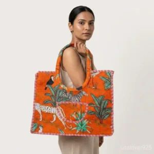 Orange Jungle Print Quilted Cotton Tote Bag with comfortable over-the-shoulder handles held against a natural background.