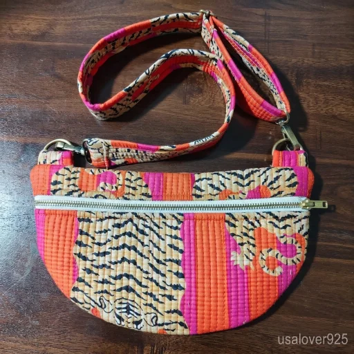 Woman at an outdoor festival carrying an Orange Tiger Print Quilted Mini Purse holding her phone and keys.