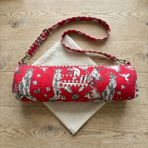 An active practitioner carrying the Red Quilted Cotton Yoga Mat Bag over the shoulder while commuting, displaying its comfortable fit and vibrant studio-ready look.
