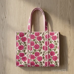 A person carrying a Pink Floral Hand Block Print Quilted Cotton Tote Bag comfortably over their shoulder during a daily office commute.
