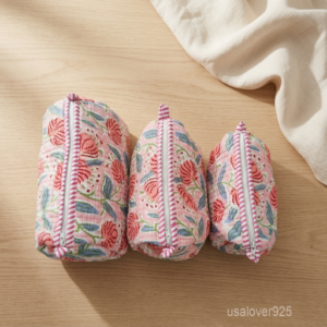 Close-up of the handcrafted pink floral print detailing, dense quilted stitching texture lines, robust fabric edges, and clean zip track on an Indian cotton toiletry pouch.