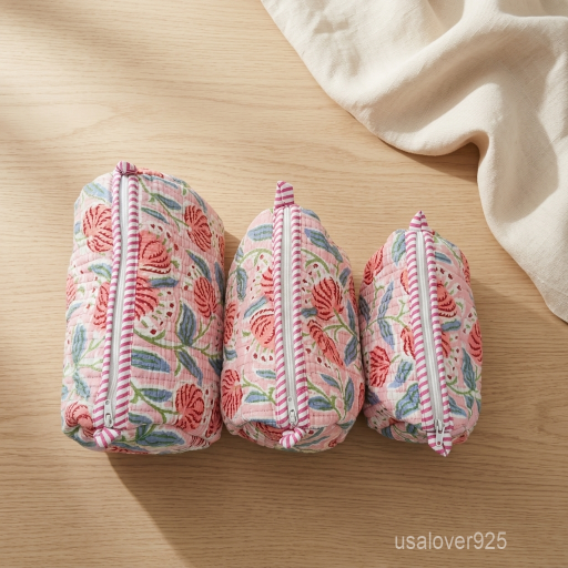 Close-up of the handcrafted pink floral print detailing, dense quilted stitching texture lines, robust fabric edges, and clean zip track on an Indian cotton toiletry pouch.