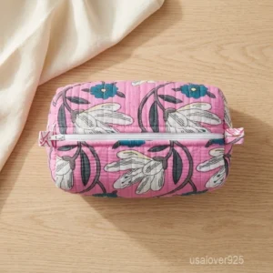 Close-up of the handcrafted pink floral print detailing, dense vertical quilted stitching rows, waterproof internal plastic lining, and built-in inside slots on an Indian cotton cosmetic caddy pouch.