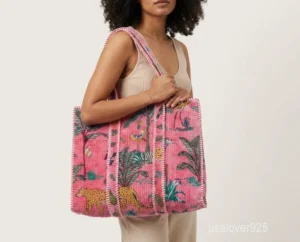 Close-up of the pink velvet floral print, dense parallel line quilted stitching rows, interior pocket, and comfortable 10-inch shoulder handles on an Indian velvet tote bag.