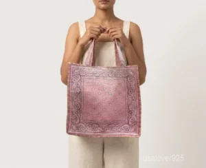 Close-up of the pink paisley bandana pattern, dense Kantha-style parallel running stitches, and comfortable double-strap handles on an Indian cotton shopper bag.